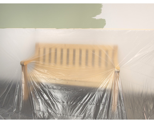 Abgedecktes Möbelstück im Raum mit Farbanstrich an der Wand.