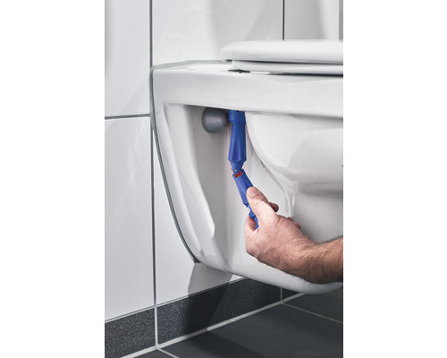 Hand, die ein Werkzeug zur Reparatur einer Toilette benutzt