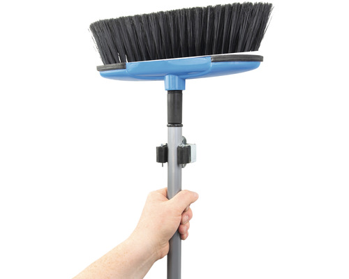 Hand hält Kehrbesen mit Teleskopstiel