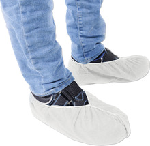 Schuhüberzieher an Füßen mit Jeans