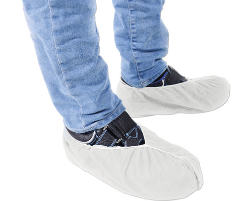 Schuhüberzieher an Füßen mit Jeans