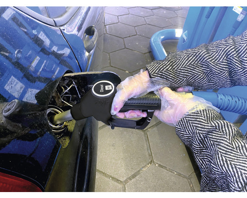 Eine Person betankt ein Auto mit Dieselkraftstoff an einer Tankstelle