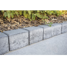 Reihe aus grauen Rasenkantensteinen aus Beton im Garten