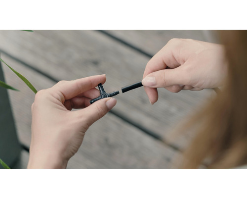 Bewässerungssystem T-Stück mit Bewässerungsschlauch in Händen