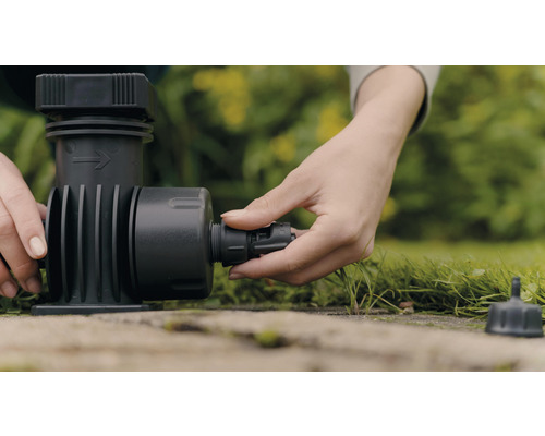 Gartenbewässerung Filter mit Hand beim Anschliessen eines Schlauches