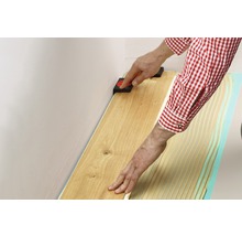 Verlegung von Parkett mit schwarzen Abstandshaltern an einer Wand