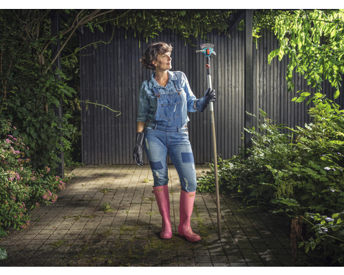 Frau im Garten mit einem Rechen und Gartengeräten