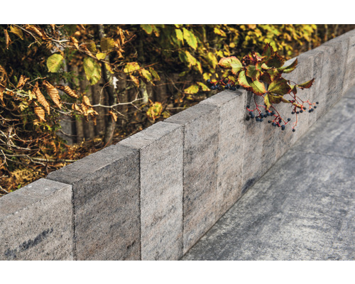 Eine Mauer aus Betonsteinen im Garten.