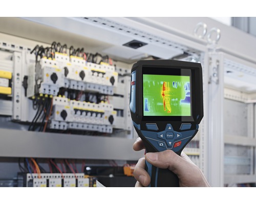 Eine Wärmebildkamera wird vor einem Schaltschrank verwendet, um Wärme zu messen.