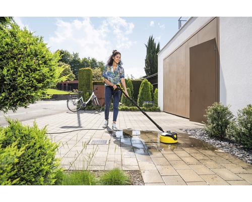 Frau reinigt Terrasse mit Terrassenreiniger und Hochdruckreiniger