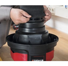 Ein Mann setzt einen Filterschaumstoff auf einen Einhell Staubsauger.