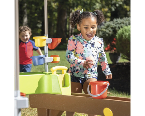 Kind spielt mit einer Wasserrutsche im Freien
