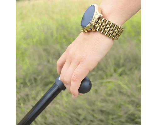 Eine Hand hält einen Gehstock und trägt eine Smartwatch mit Metallarmband.