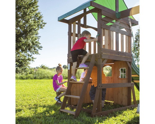 Spielplatz mit Holzhaus, Leiter und Rutsche im Garten mit spielenden Kindern