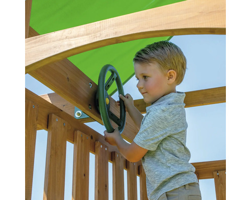 Junge spielt mit einem Lenkrad an einem Spielturm aus Holz