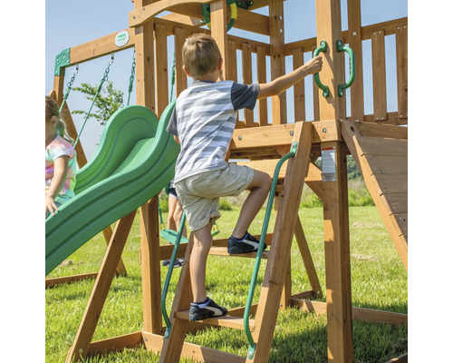 Kind klettert auf ein Holzspielgerät mit Rutsche und Schaukel