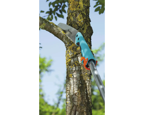 Eine Astsäge schneidet einen Ast an einem Baum.