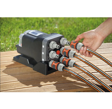 Gardena Wasserverteiler Automatic mit sechs Anschlüssen und angeschlossenen Gartenschläuchen auf einer Holzoberfläche