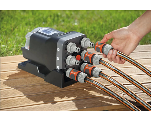 Gardena Wasserverteiler Automatic mit sechs Anschlüssen und angeschlossenen Gartenschläuchen auf einer Holzoberfläche