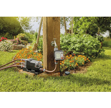 Gartenbewässerungssystem mit Wasserverteiler und Bewässerungscomputer im Garten