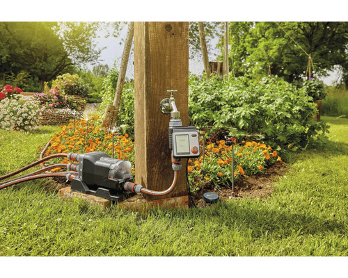 Gartenbewässerungssystem mit Wasserverteiler und Bewässerungscomputer im Garten