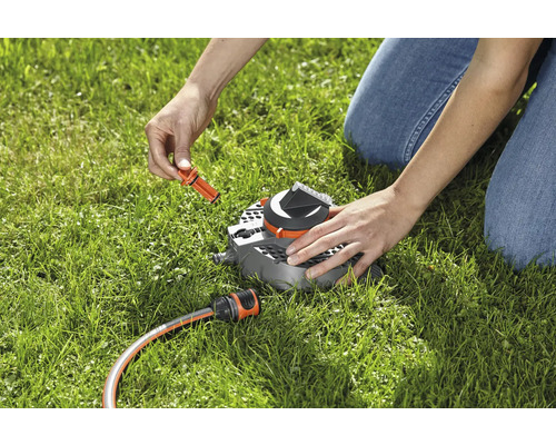 Aufnahme eines Regners mit Gartenschlauchanschluss auf Rasen während des Installationsprozesses