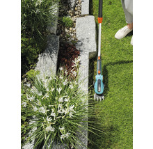 Gardena Akku-Grasschere mit Teleskopstiel im Einsatz in einem Garten.