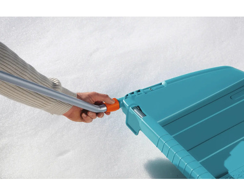 Schneeschieber mit Hand am Griff im Schnee