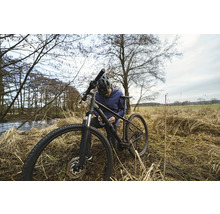 Ein Mann repariert sein Fahrrad in der Natur