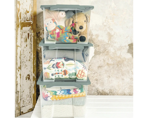 Drei transparente Aufbewahrungsboxen mit Spielzeug und Kleidung gestapelt