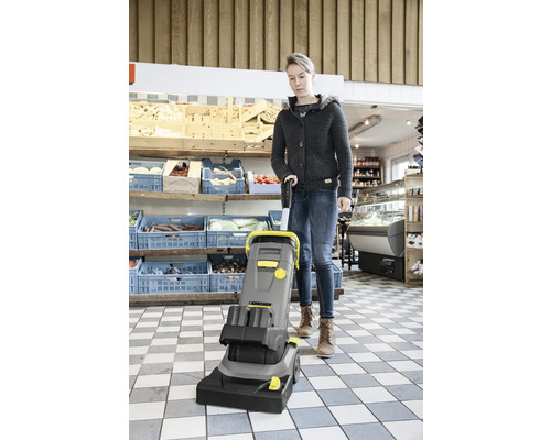 Eine Frau bedient ein Teppichreinigungsgerät in einem Geschäft.