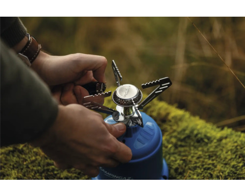 Person bedient Campingkocher von Campingaz im Freien.