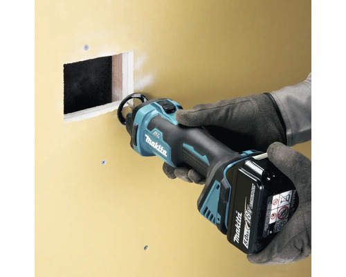 Makita Logo. Trockenbausäge im Einsatz an einer Wand.