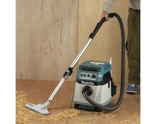 Makita Staubsauger beim Aufsaugen von Sägemehl auf dem Boden.