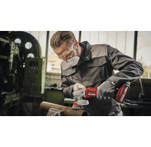Ein Mann mit Schutzbrille und Staubmaske schleift ein Rohr mit einem Einhell Akku-Winkelschleifer.