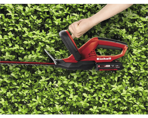 Einhell Heckenschere im Einsatz vor einer grünen Hecke
