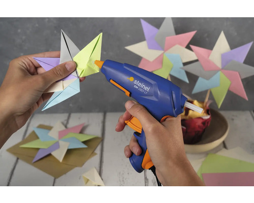 Eine Heißklebepistole wird verwendet, um einen Papierstern zu befestigen.