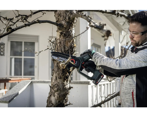 Mann schneidet Baum mit Akku-Kettensäge von Metabo