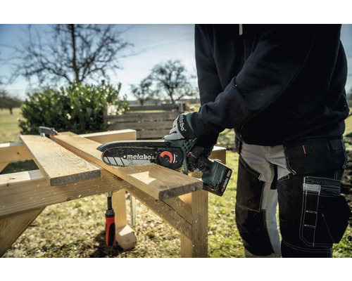 Person sägt Holz mit einer Metabo Akku-Kettensäge