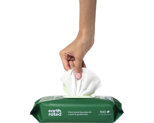 Eine Hand zieht ein Feuchttuch aus einer Packung Hundefeuchttücher.