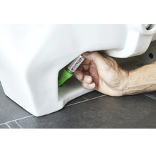 Hand dichtet Toilette mit Dichtstoff ab