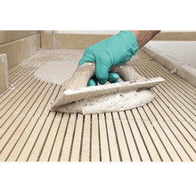 Verlegen von Mosaikfliesen mit einem Spachtel