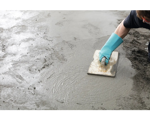 Handwerker glättet Estrich mit einer Glättkelle
