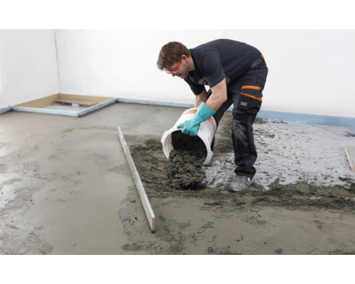 Handwerker gießt Estrich auf einen Boden