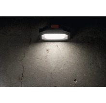 Metabo Logo. Auf dem Bild ist eine Arbeitsleuchte zu sehen, die einen Betonboden beleuchtet.