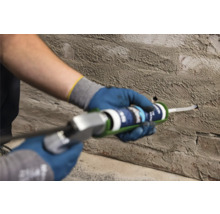 Handwerker füllt ein Loch in einer Wand mit Dichtstoff