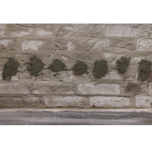 Backsteinmauer mit Mörtelflecken