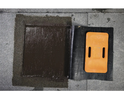 Detailansicht einer Dachreparatur mit Bitumen und Dichtungsband