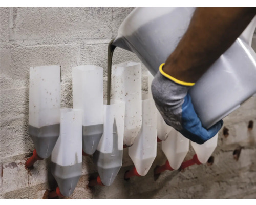 Person schüttet Masse in Injektionskanister zur Mauertrockenlegung