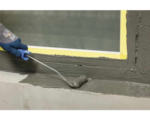 Auftragen einer Abdichtung mit einer Farbwalze im Innenbereich.